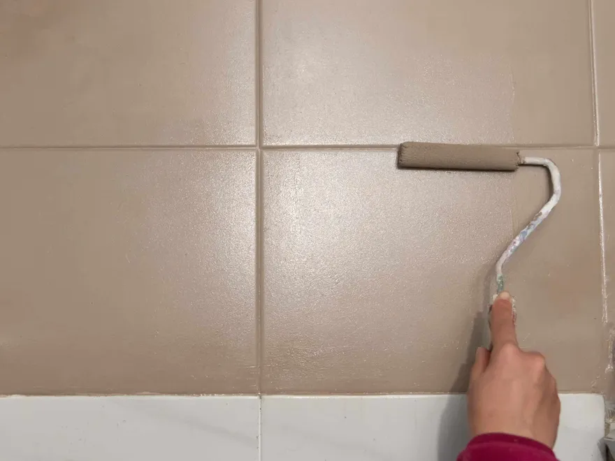 Painting bathroom tiles with a small foam roller